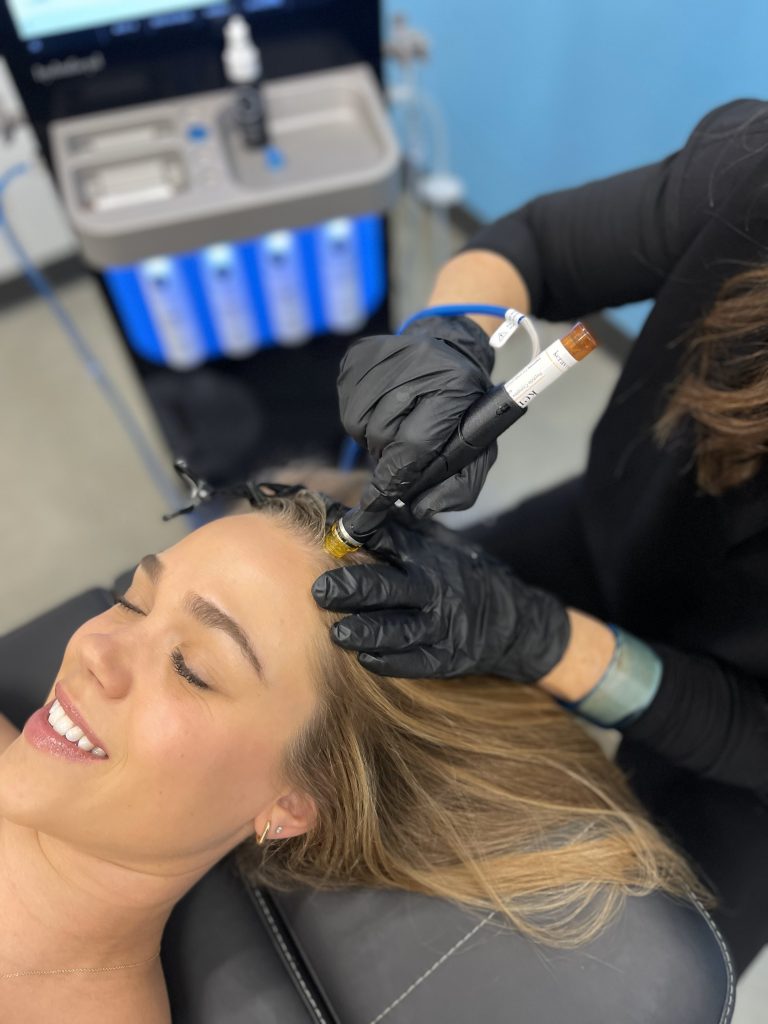 Woman having a Keravive scalp treatment